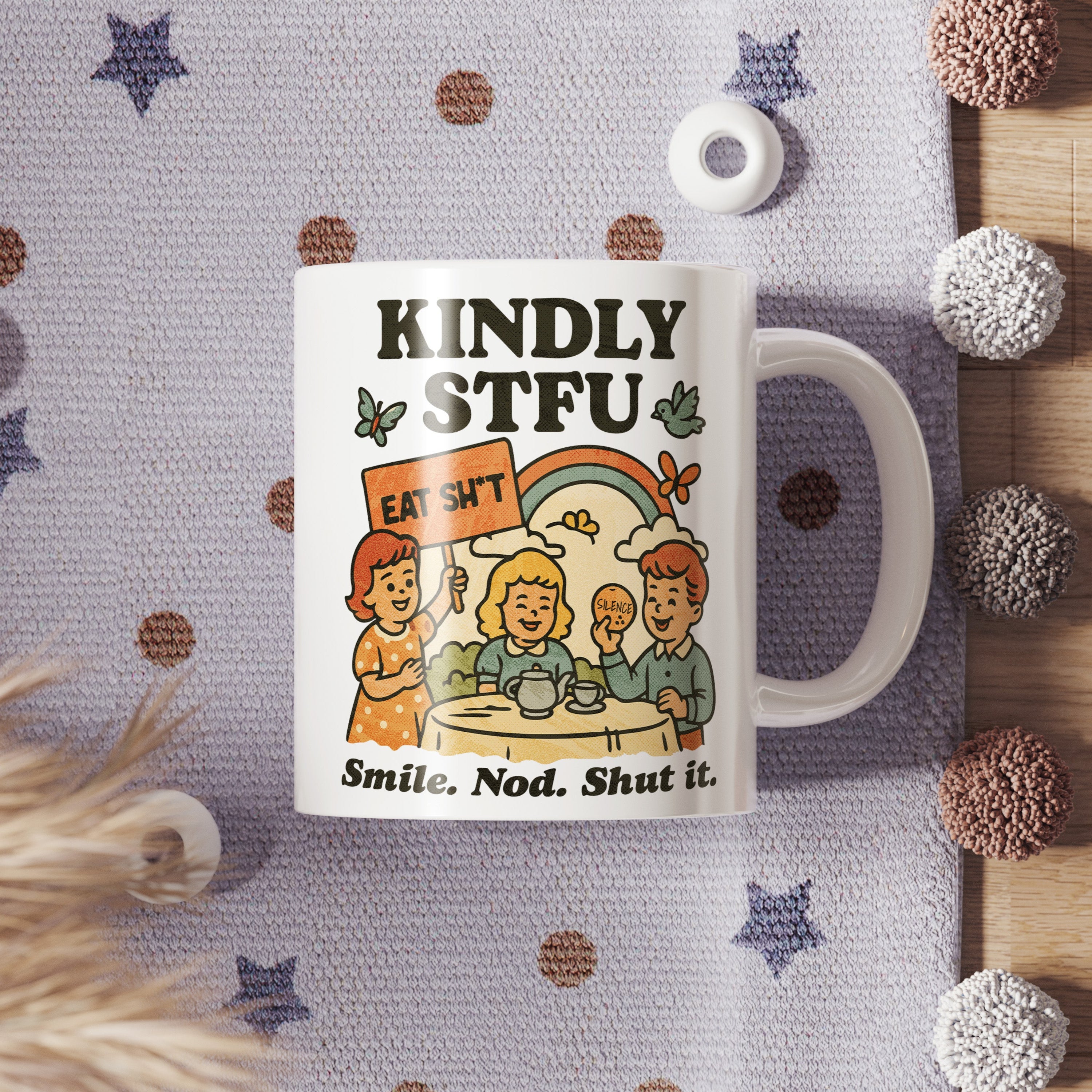 Mug with a graphic design and text on a textured surface with decorative items.