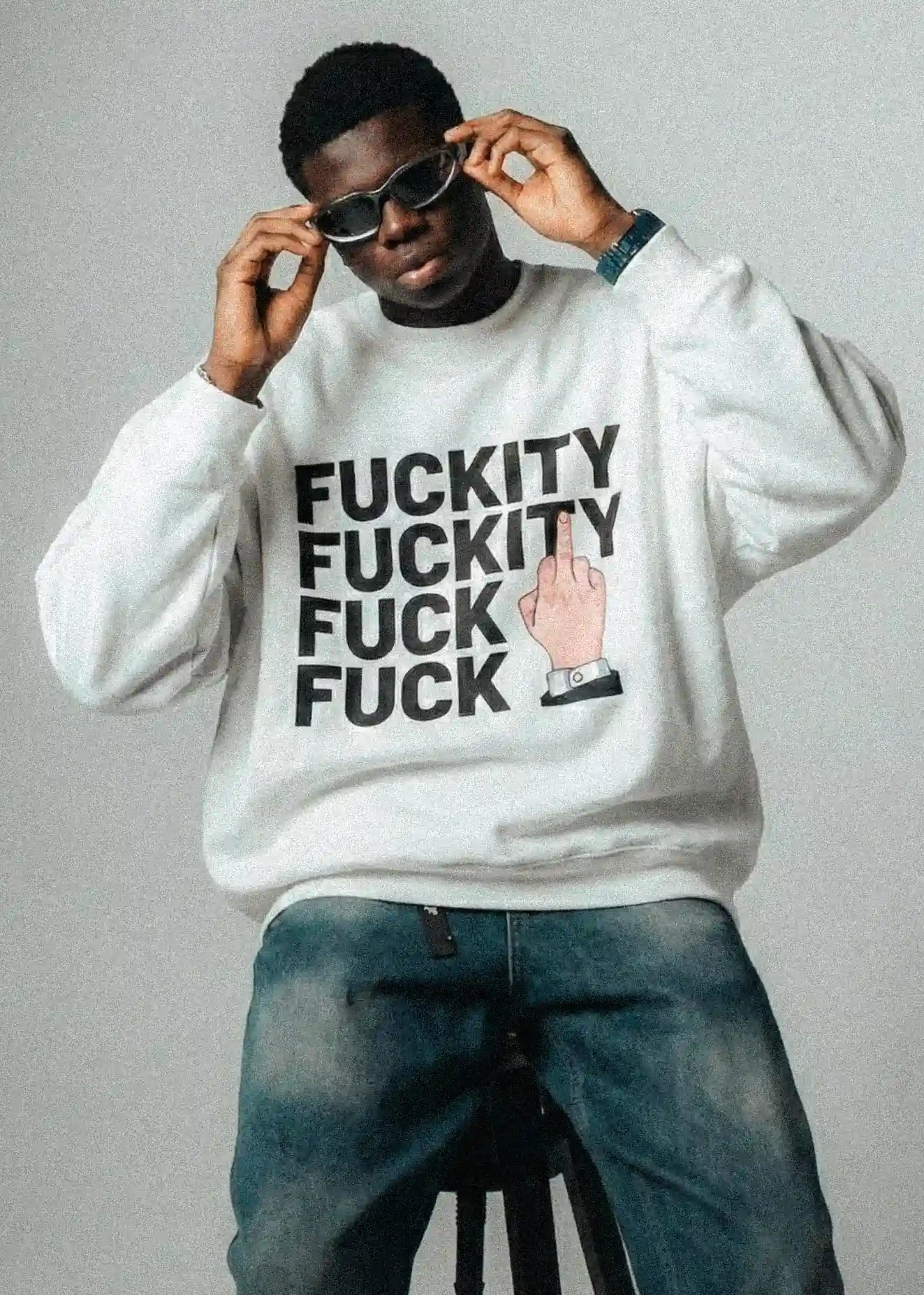 Person wearing a white sweatshirt with graphic text and design.