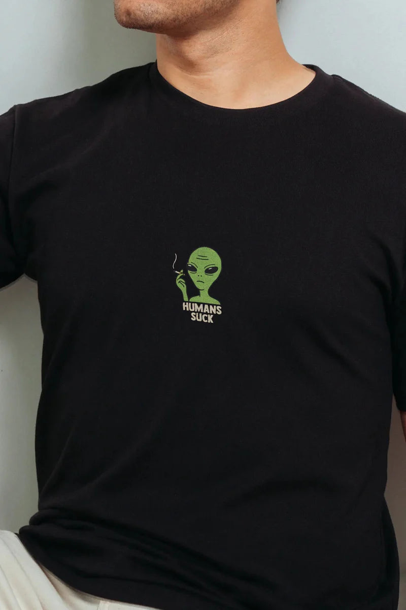 Black t-shirt with a green alien graphic and text "Humans Suck".